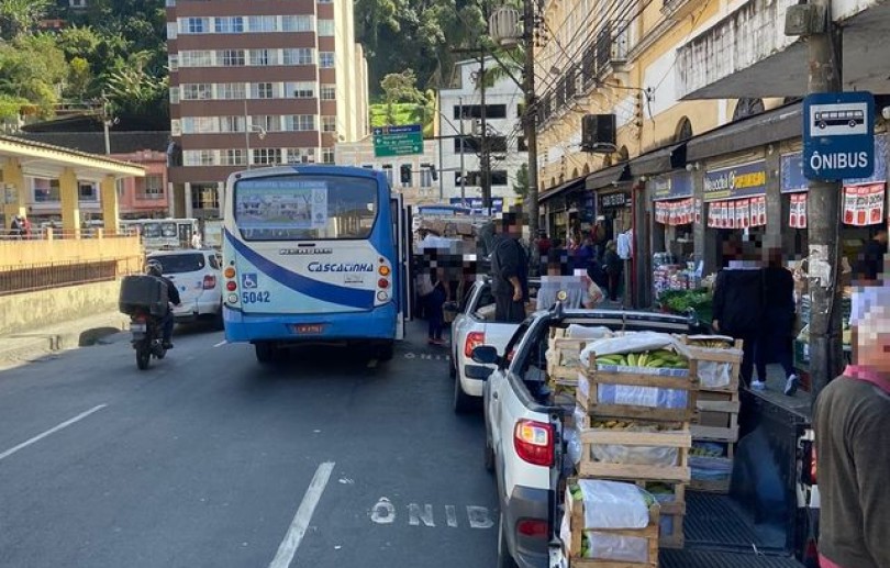 Passageiros precisam embarcar no meio da via devido à ocupação irregular de carros e caminhões no ponto de ônibus na Rua Caldas Viana